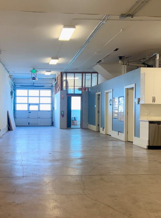 Interior showing drive-in door, polished concrete floors, and high ceilings